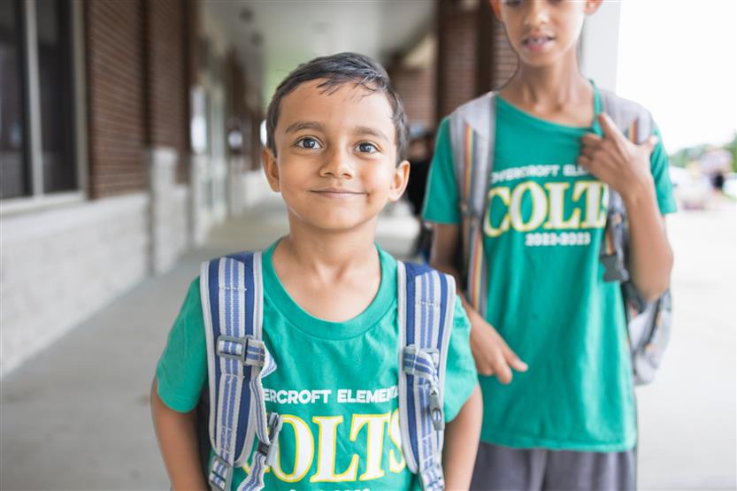 A boy wearing a green shirt smiles